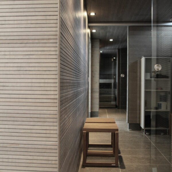 An audible grey panel in the bathroom's horizontal display gives the space an elegant and calming look. When used over a wide area, the panel emphasises the clarity of the space and creates a harmonious overall effect. The audible surface brings out the natural grain patterns of the wood, adding subtle texture and elegance to the bathroom.