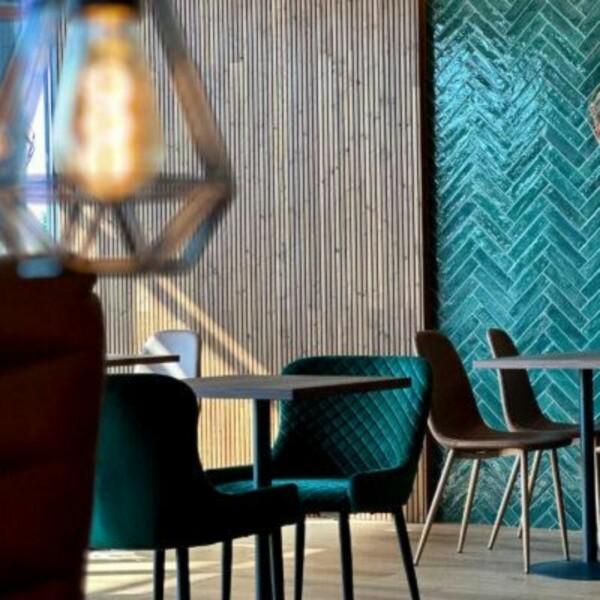 thermally modified The PURO decorative panel combined with the beautiful green tile creates a harmonious and fresh look. The natural grain patterns and warm shade of the wood accentuate the unique atmosphere of the space, where modernity and naturalness meet in an elegant way.